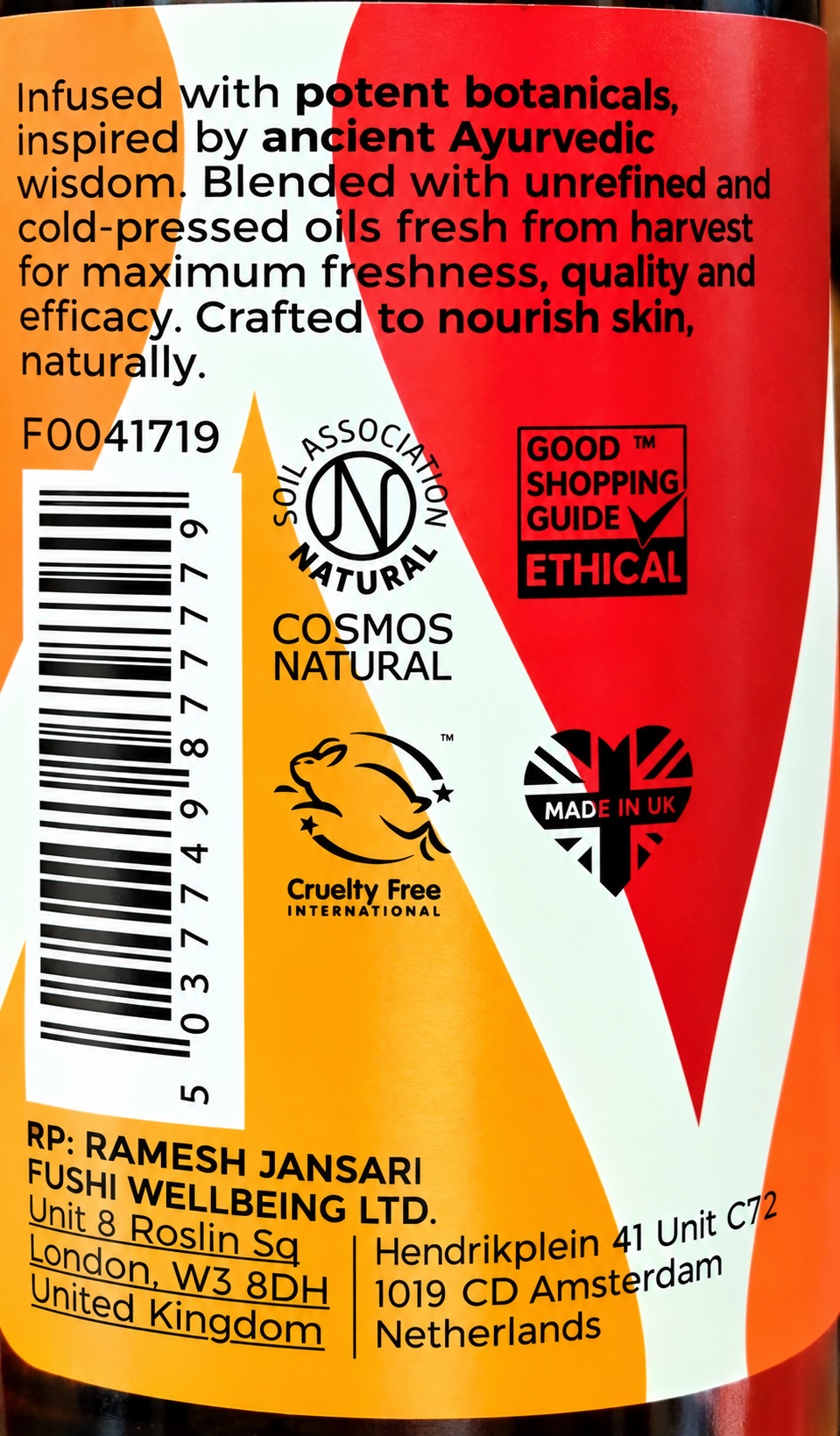 Close-up of a cosmetic bottle label with text and logos, including 'COSMOS NATURAL', 'SAIL ASSOCIATION NATURAL', 'GOOD TM SHOPPING GUIDE ETHICAL', 'Cruelty Free International', and 'MADE IN UK'.