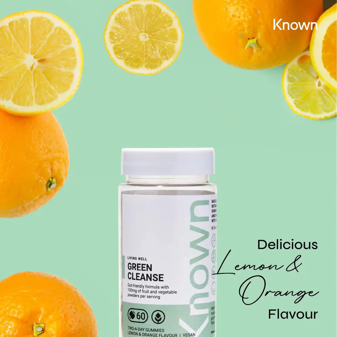 "Known Green Cleanse Gummies VEGAN bottle surrounded by fresh lemons and oranges, emphasizing the delicious natural flavor."