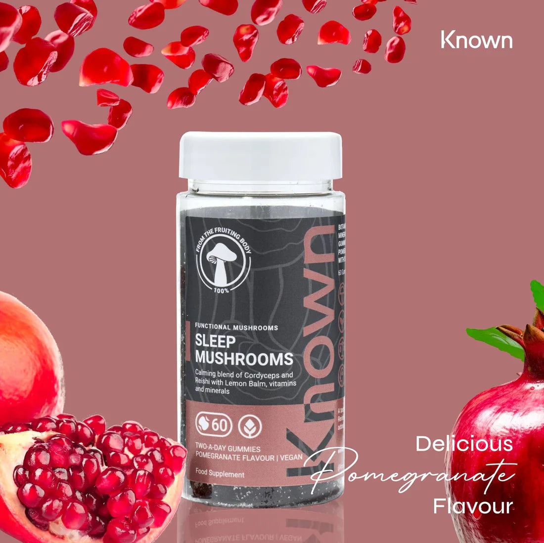 "Known Sleep Mushrooms Gummies VEGAN bottle surrounded by fresh pomegranates, emphasizing the delicious natural flavor."