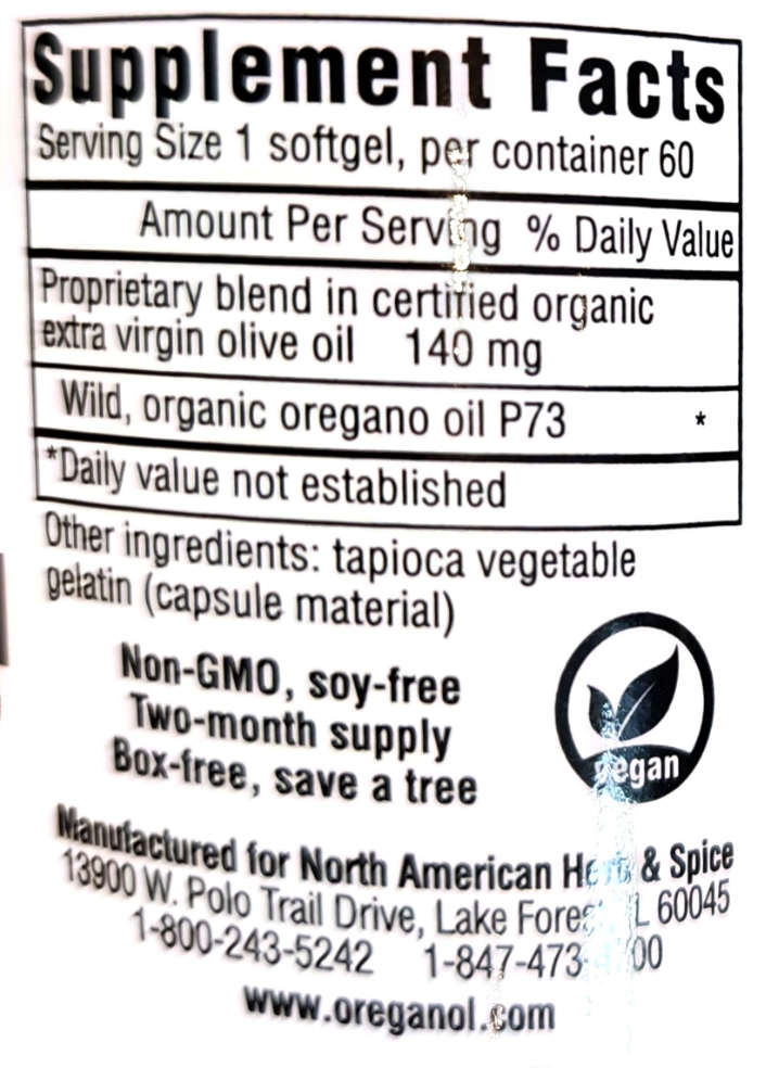 Close-up of a supplement facts label with text about a softgel product, including ingredients, serving size, and a circular vegan logo. The label is photographed against a dark background.