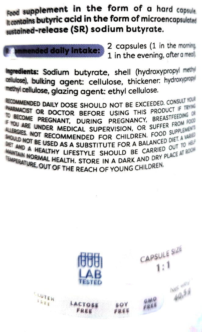 Close-up of a white supplement bottle label showing text about daily intake, ingredients, and a blue LAB tested logo.