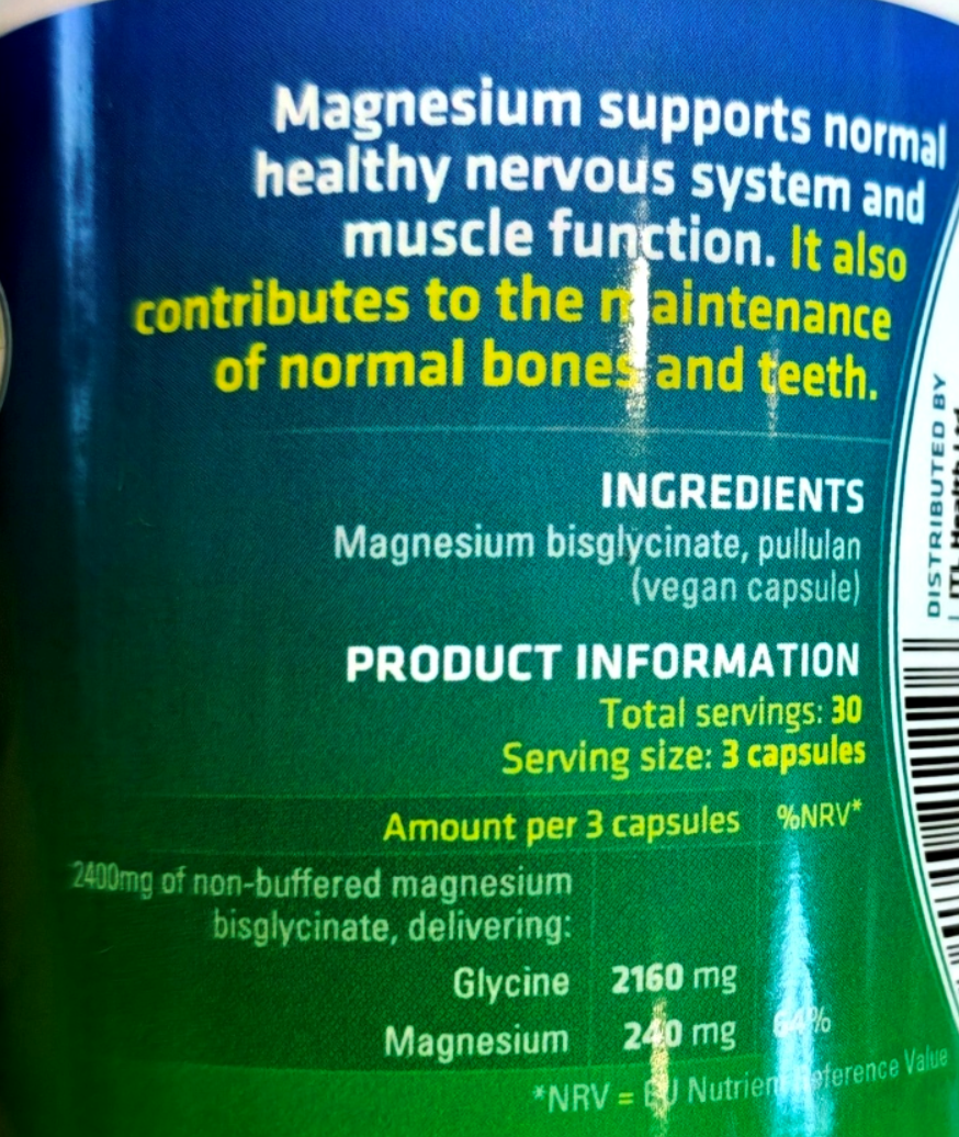 Close-up of the back of a dark green supplement can showing product information text about magnesium bisglycinate, including ingredients, servings, and mg amounts.