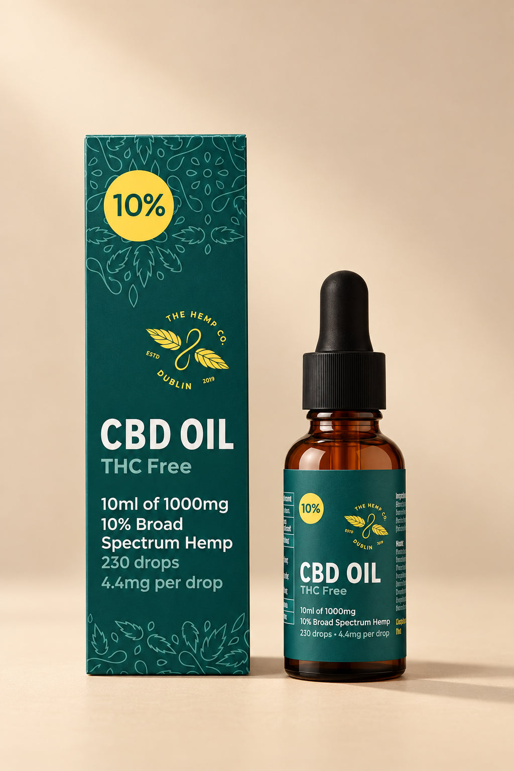 The image shows a bottle of The Hemp Company Broad Spectrum CBD Oil 10% alongside its packaging. The bottle is dark amber with a white label indicating the product is CBD Oil with 10% concentration, THC-free, and comes in a 10ml size.