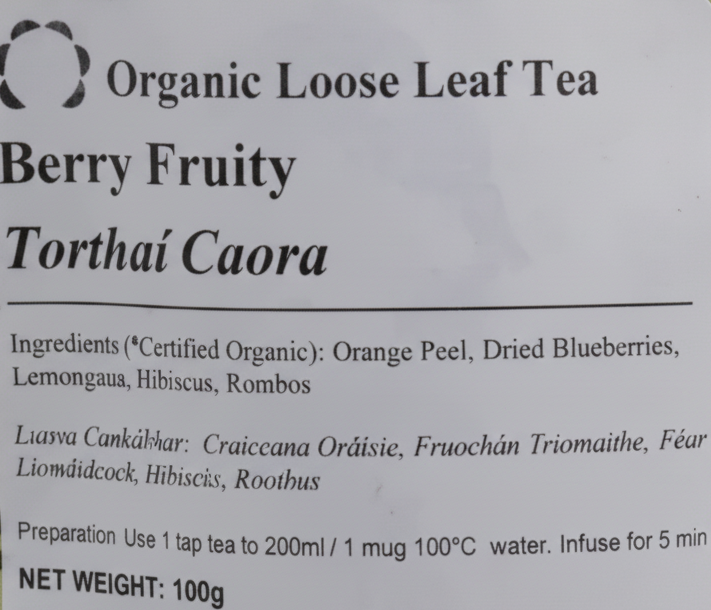 A close-up of a white product label for Organic Loose Leaf Tea, variety Berry Fruity Torthai Caora, showing ingredients and net weight details.