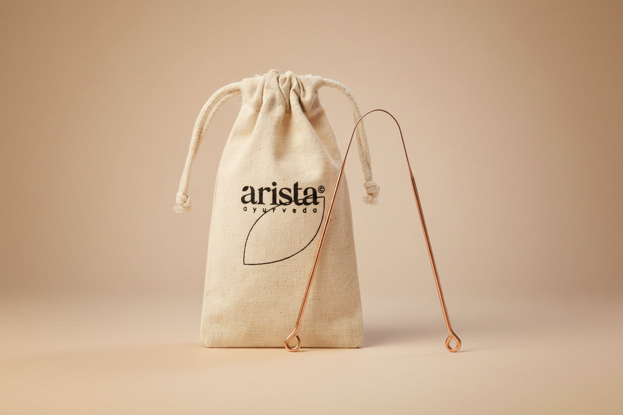 Copper hook with 'arista ayurveda' logo on a beige drawstring bag