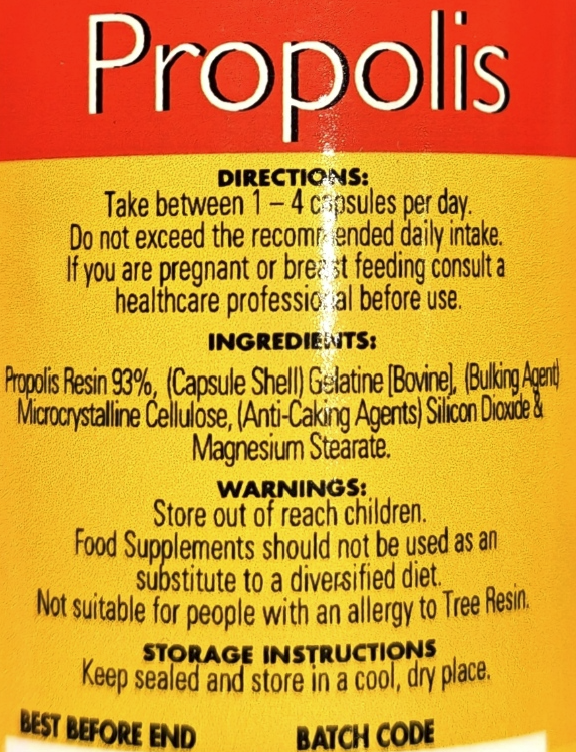 Close-up of a supplement label reading 'Propolis' in large white text on a red header, with yellow background and black directions, ingredients, warnings, and storage instructions.