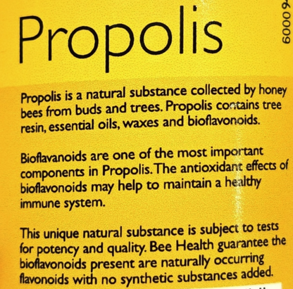 A close-up of a yellow product label with the word 'Propolis' in large black text and several paragraphs of smaller black text describing its natural components and benefits.