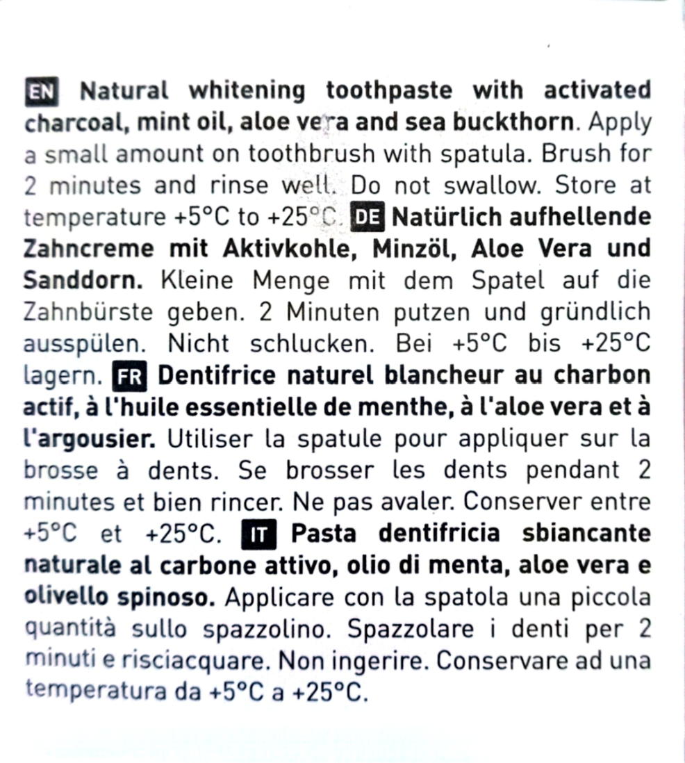 A close-up of a printed toothpaste package showing multilingual product instructions in English, German, French, and Italian on a white background.