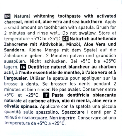 A close-up of a printed toothpaste package showing multilingual product instructions in English, German, French, and Italian on a white background.