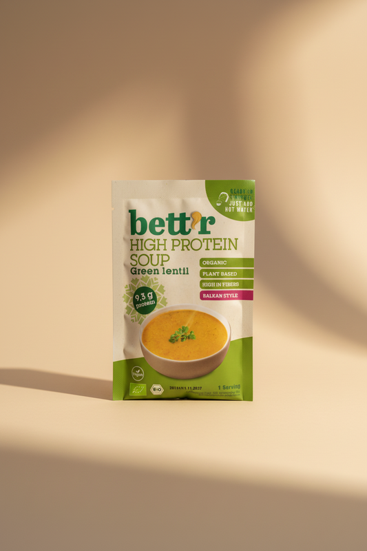 A package of better High Protein Soup Green lentil, featuring a white and green bag with a bowl of orange soup on the front, set against a dark wooden background.