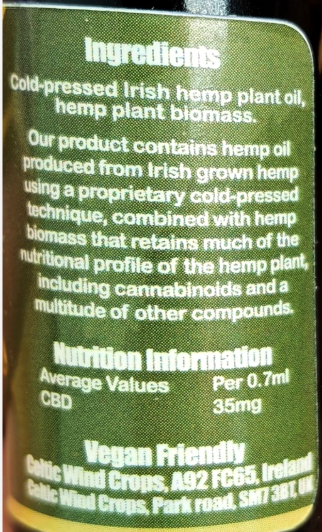 Close-up of a dark green label showing product ingredients and nutrition information for cold-pressed Irish hemp plant oil and biomass, with CBD average values of 35mg per 0.7ml.