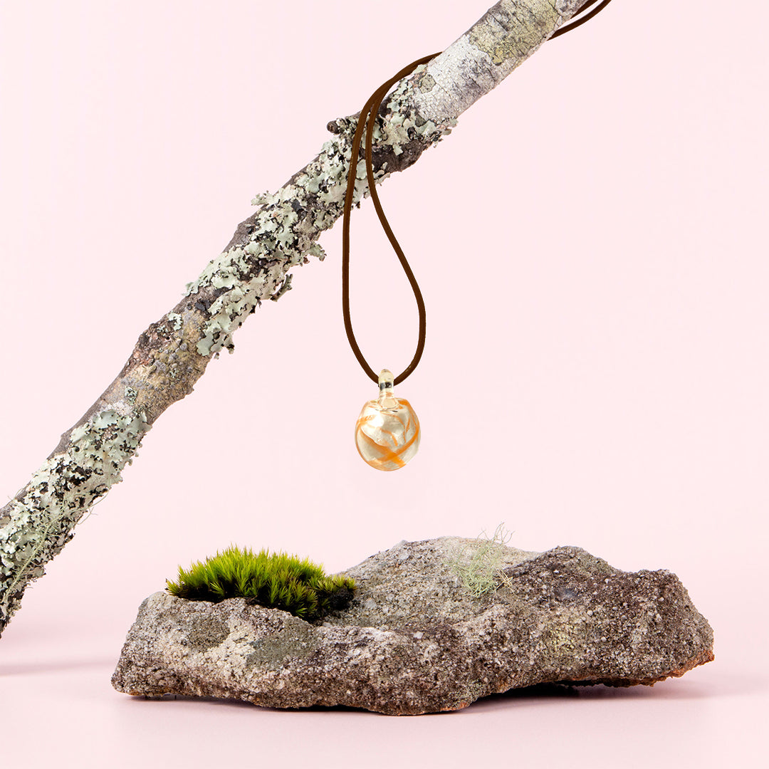 Australian Bush Flower glass pendant hanging from a branch