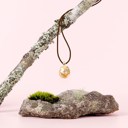 Australian Bush Flower glass pendant hanging from a branch