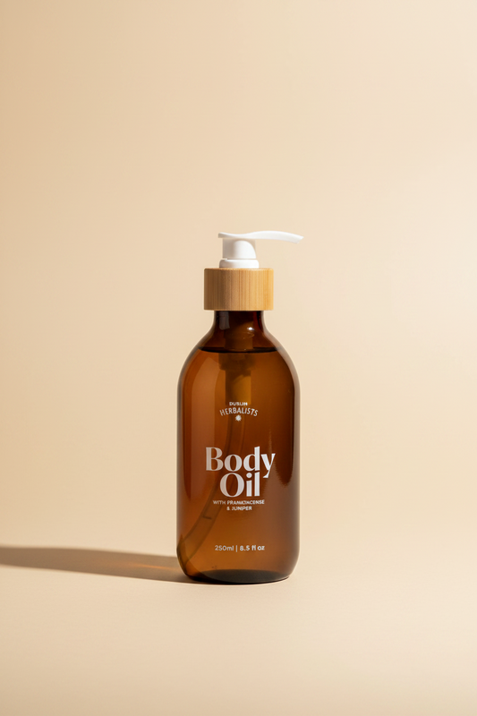 Döléin Herbalists Body Oil in a 250ml (8.5 fl oz) amber glass bottle with a bamboo collar and white pump dispenser, shown on a plain white background.