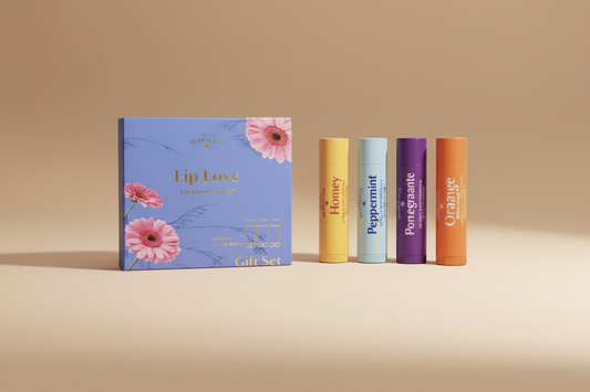 Herbalist's 'Lip Love' lip balm gift set, featuring a blue floral box next to four individual lip balms in yellow, light blue, purple, and orange.