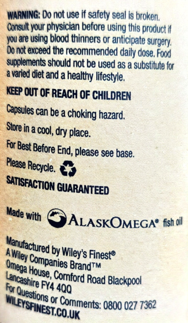 Back of a supplement package showing warning text, storage instructions, a recycling symbol, and manufacturer details for Wiley's Finest by Alaska Omega fish oil.