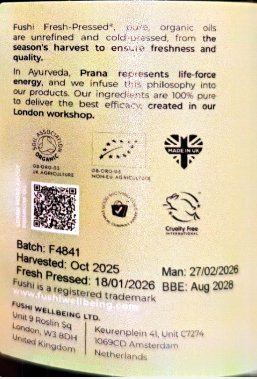 Back of a Fushi Fresh-Pressed product package showing ingredients, batch number, harvest date, manufacturing details, and certification logos on a cream-colored background.