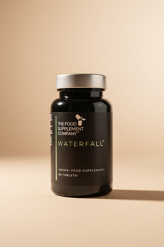 Black supplement bottle labeled 'The Food Supplement Company Waterfall' on a textured surface.