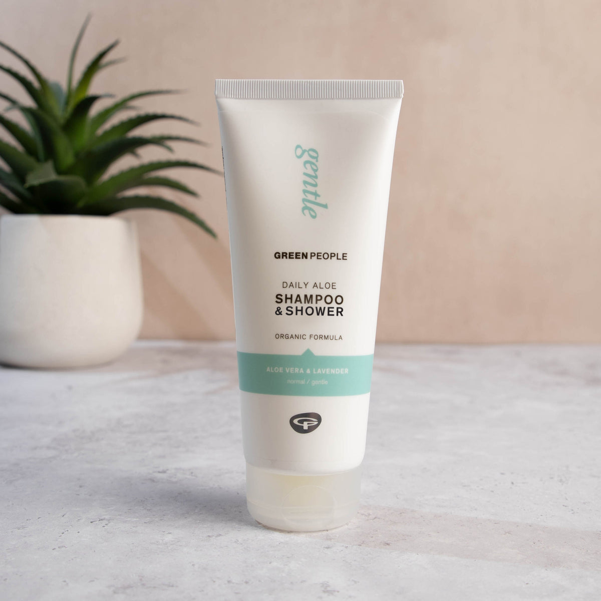 Green People Daily Aloe Shampoo & Shower Wash 200ml standing beside an aloe plant