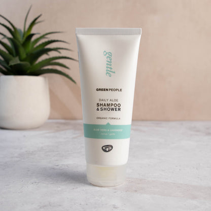 Green People Daily Aloe Shampoo & Shower Wash 200ml standing beside an aloe plant
