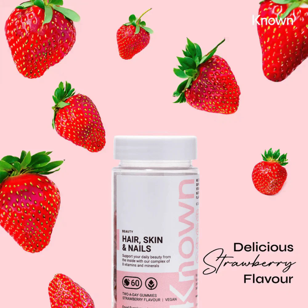 "Known Hair, Skin & Nails Gummies VEGAN bottle surrounded by strawberries, emphasizing the delicious natural flavour."