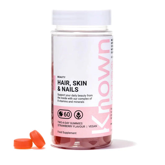 "Front view of Known Hair, Skin & Nails Gummies VEGAN, 60-count bottle with a couple of gummies around it."