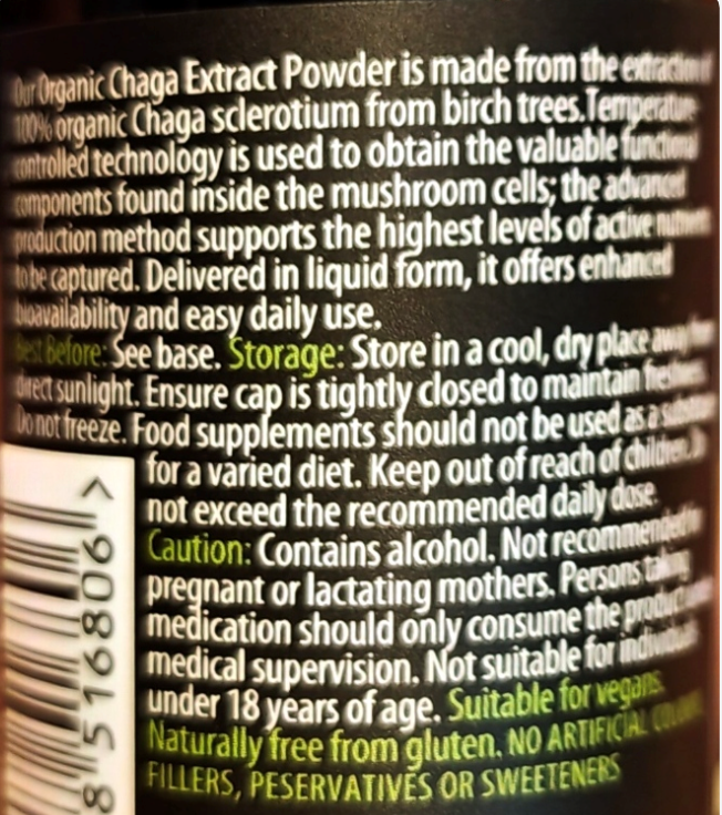 Close-up of a black bottle label showing white text describing organic Chaga extract powder, with a barcode on the left and storage and caution instructions.