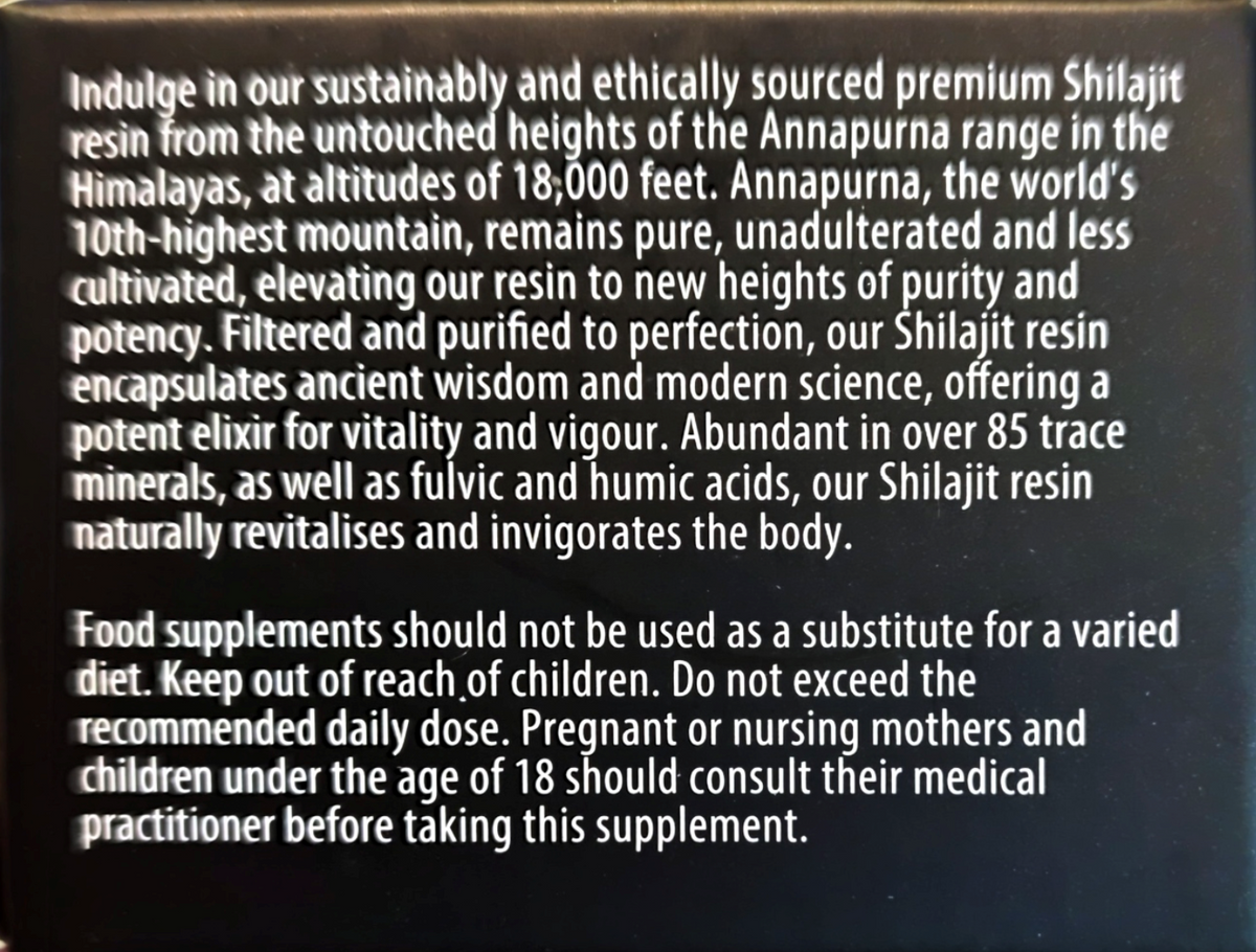 A close-up of a supplement product's packaging showing white text on a black background. The text describes the product as Shilajit resin, mentioning the Annapurna range in the Himalayas, its pure and unadulterated quality, and health benefits.