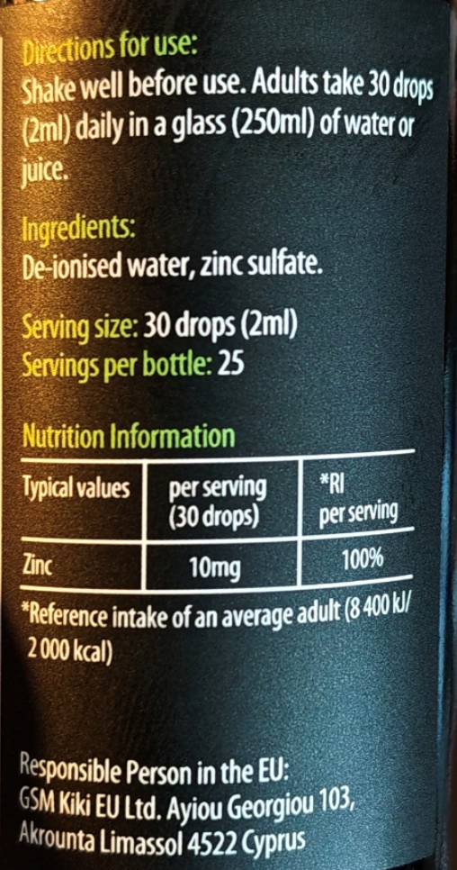 Close-up of a supplement bottle label showing usage directions, ingredients, serving size, nutrition information, and responsible person text in white and green text on a dark background.