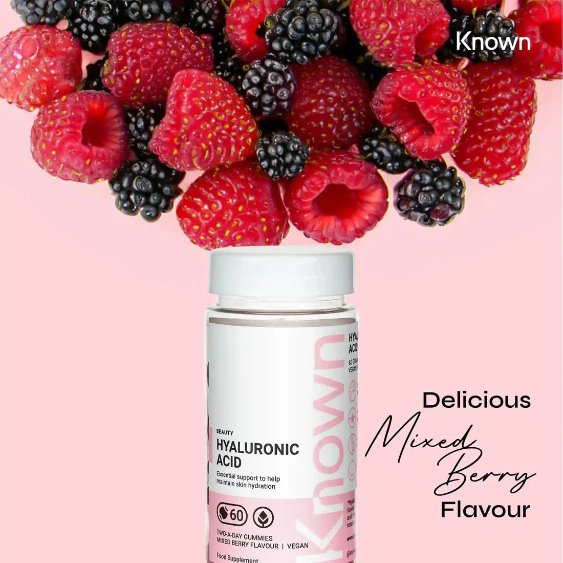 "Known Hyaluronic Acid Gummies VEGAN bottle surrounded by fresh mixed berries, emphasizing the delicious natural flavor."