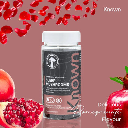 "Known Sleep Mushrooms Gummies VEGAN bottle surrounded by fresh pomegranates, emphasizing the delicious natural flavor."