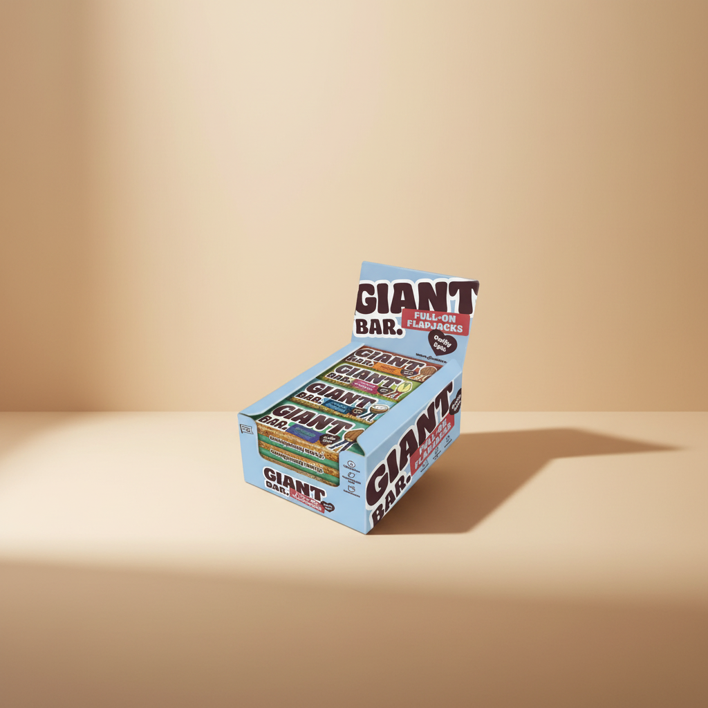 A light blue Giant Bar snack display box filled with multiple wrapped bars, shown on a plain white studio background. The box prominently reads 'GIANT BAR' and 'FULL-ON FLAPJACKS,' with flavor labels visible on the bars inside.