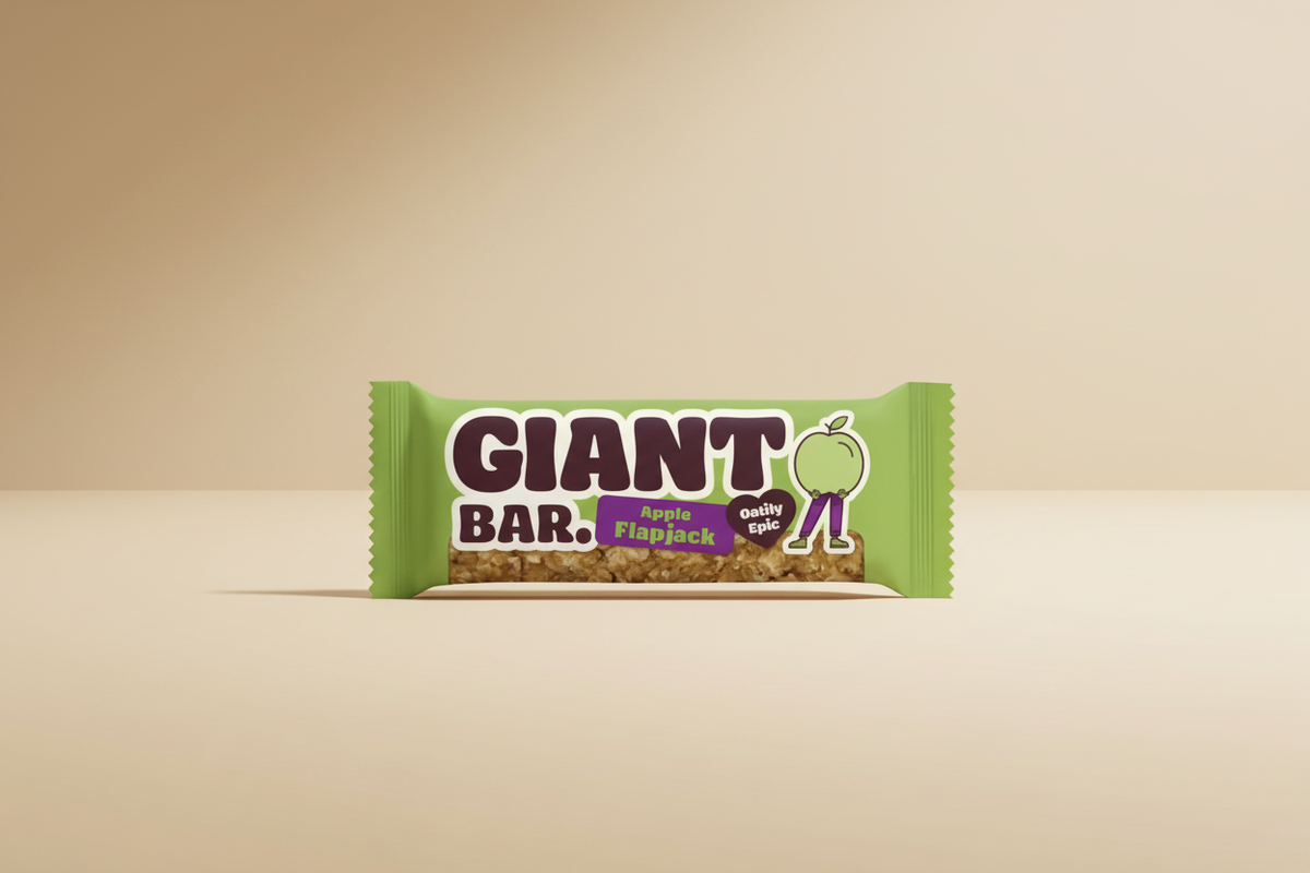 A packaged snack bar labeled GIANT BAR. Apple Flapjack, shown in a bright green wrapper with a visible piece of granola and fruit filling.