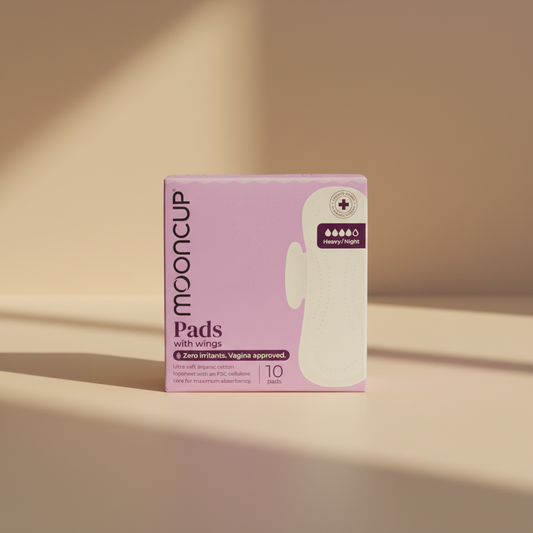 A box of Mooncup Pads with wings, size 10, featuring a light purple background and a graphic of a white sanitary pad with wings. The box highlights 'Zero irritants.