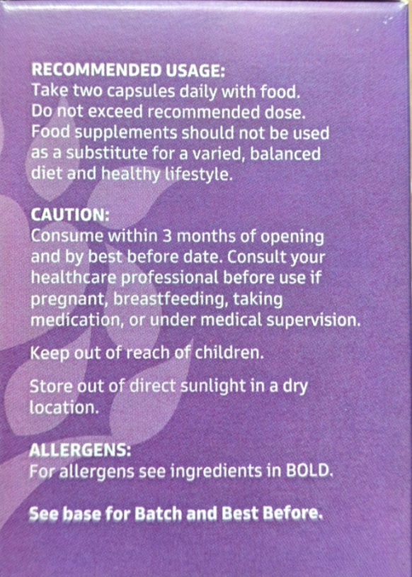 A close-up of a purple product box showing white printed usage and caution text, including recommended dosage and storage instructions.