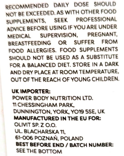 Close-up of a white supplement package showing black printed warning and manufacturer information text.
