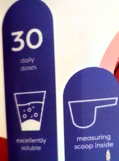 Close-up of a product package showing blue informational panels with white text and icons: '30 daily doses,' 'excellent soluble,' and 'measuring scoop inside.'.
