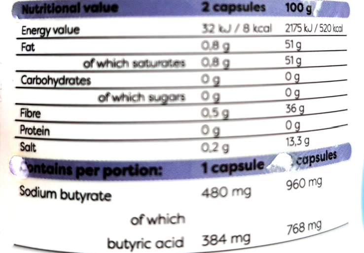 Close-up of a supplement label showing nutritional information and dosage details for sodium butyrate and butyric acid, with text indicating 2 capsules at 100 g and 1 capsule portion.