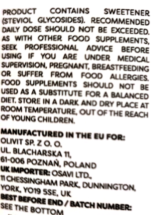 A close-up of a product label showing warning text in English, including 'Product contains sweetener' and manufacturing details for Olivit SP. Z O.