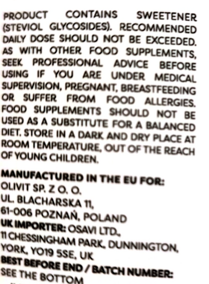 A close-up of a product label showing warning text in English, including 'Product contains sweetener' and manufacturing details for Olivit SP. Z O.