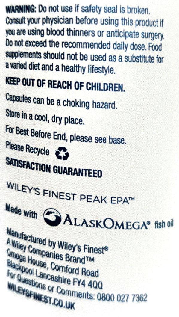 Close-up of a printed product label with warning text, a recycling symbol, and the AlaskOmega fish oil branding on a white background.