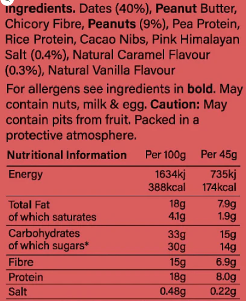 A close-up of a red packaging label showing the ingredients list and nutritional information for a peanut butter snack. The label lists ingredients such as peanut butter, rice protein, and pink Himalayan salt, with a caution note about pits from fruit.
