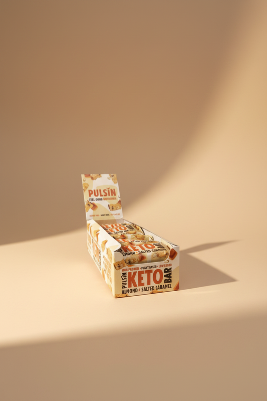 Box of Pulsin' Keto bars with a hand holding it against a neutral background