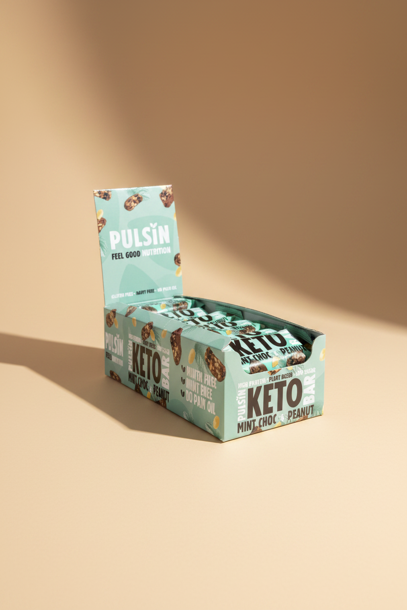 Box of Pulsin' Keto Mint Choc Peanut bars held by a hand on a gray background