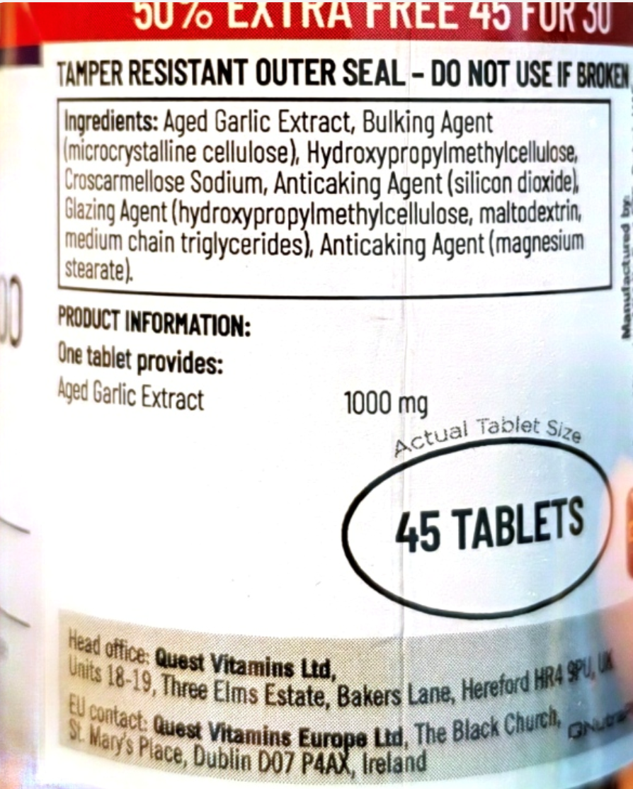 Close-up of a supplement label showing product information, ingredients, and a white oval marking that says '45 TABLETS'. Visible text includes Quest Vitamins Ltd and 1000 mg.