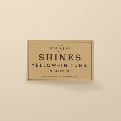 Shines Yellowfin Tuna in Olive Oil – 111g — original product packaging on warm beige background