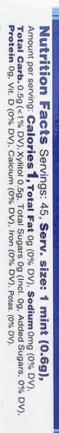 A close-up of a printed nutrition facts panel with vertical text showing calories, fat, protein, carb, sodium, and other nutrients on a white background.