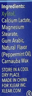 A close-up of a blue ingredient label with white text listing Xlear products, including Xylitol, Calcium Lactate, Magnesium Stearate, Gum Arabic, Natural Flavor (Pepermint Oil), Carnauba Wax, and storage/manufacturer details.