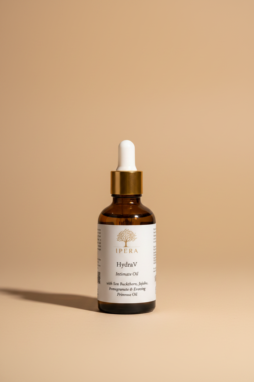 An amber glass dropper bottle of IPERA HydraV Intimate Oil with a white label and gold cap, shown against a plain white background.