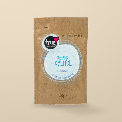 True Natural Goodness Xylitol 250g — original product packaging on warm beige background
